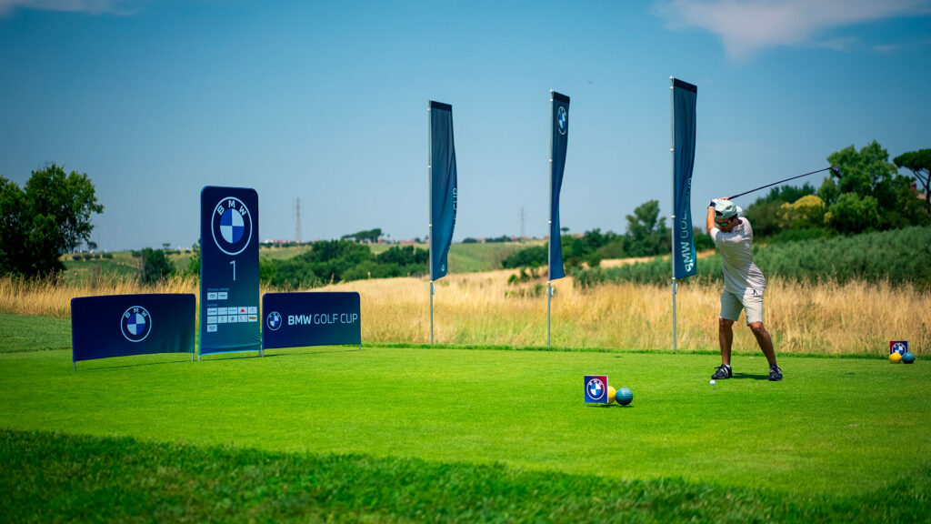 Un golfista colpisce la palla durante un evento della BMW Golf Cup