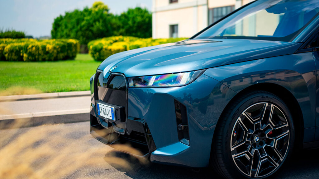 Parte anteriore di un'auto BMW blu parcheggiata, con fari accesi