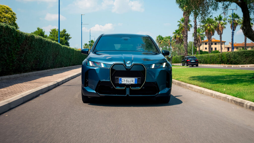 Vediamo una BMW blu ripresa frontalmente su strada