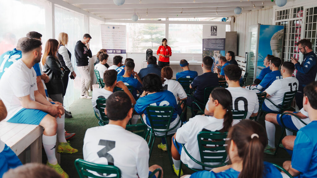 Vediamo una squadra di calcio che ascolta una presentazione in una sala