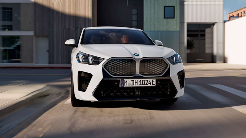 Vediamo una BMW iX2 bianca su una strada di città