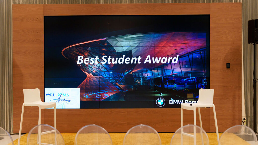 Vediamo un grande schermo con la scritta "Best Student Award".