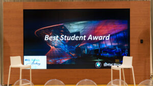 Vediamo un grande schermo con la scritta "Best Student Award".